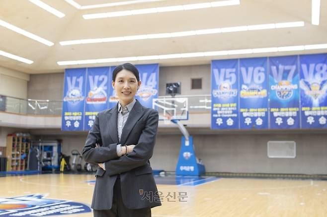 14년 코치 생활을 마치고 여자프로농구 아산 우리은행 새 사령탑에 오른 전주원 감독이 지난 17일 서울 성북구 우리은행 체육관에서 우승 현수막을 배경으로 기념촬영을 하고 있다.