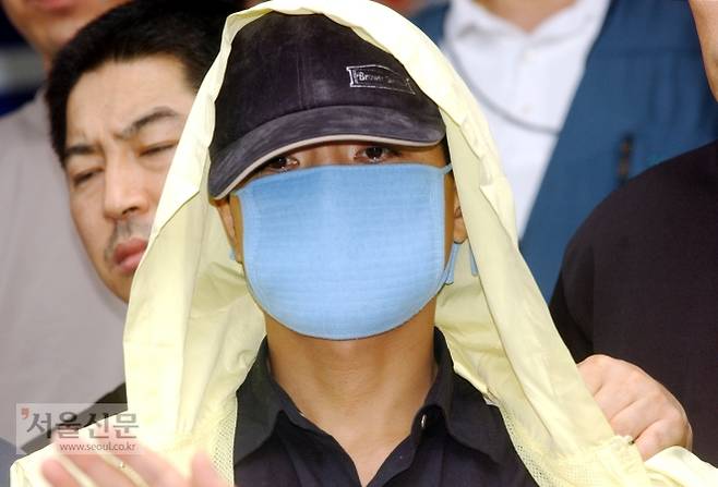 연쇄살인범 유영철이 2004년 7월 18일 서울 마포경찰서에서 수사를 받은 뒤 언론에 모습을 드러내고 있다. 김명국 daunso@