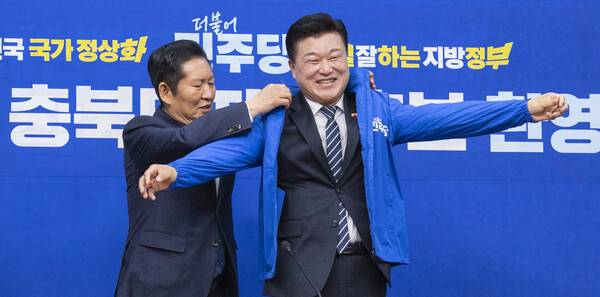 민주당 정청래 대표가 지난 14일 민주당 충남도지사 후보로 확정된 신용한 후보에게 파란색 점퍼를 입혀주고 있다. 2026.4.14&nbsp; 연합뉴스