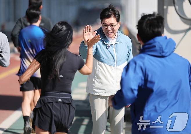 정원오 더불어민주당 서울시장 후보가 25일 오전 서울 서초구 반포한강공원에서 열린 '찾아가는 현장: 러닝편'에서 러너들과 하이파이브를 나누고 있다. 2026.4.25 ⓒ 뉴스1 오대일 기자