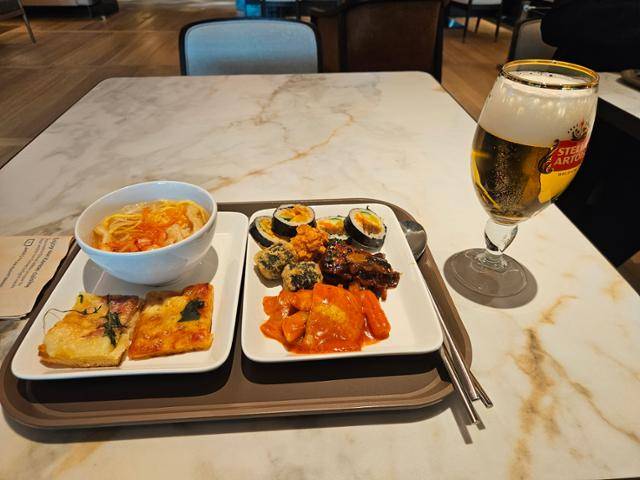 15일 대한항공 인천공항 2터미널 프레스티지 서편 라운지에서 김밥, 김말이, 떡볶이, 잔치국수 등 한식 메뉴와 피자를 맥주와 곁들여 식사했다. 김경준 기자