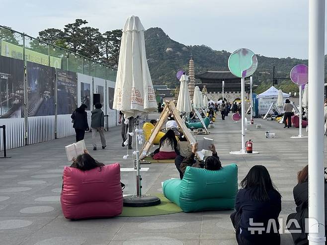 [서울=뉴시스] 김세은 인턴기자 = 23일 서울 광화문광장에 마련된 '광화문 책마당'에서 시민들이 책을 읽고 있다.2026.04.23.