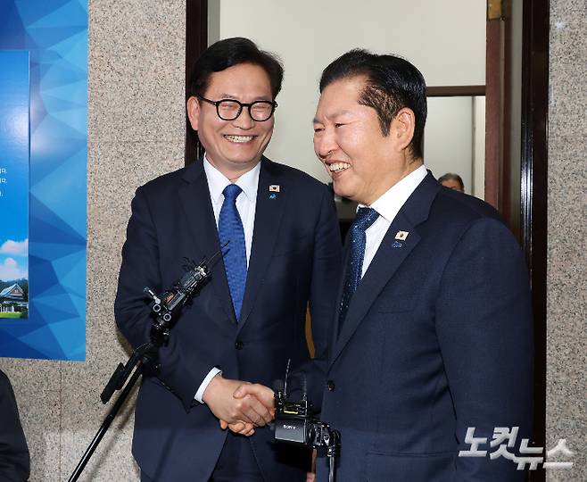 더불어민주당 정청래 대표(오른쪽)와 복당한 송영길 전 대표가 5일 국회 당대표실에서 면담 후 악수하고 있다. 황진환 기자