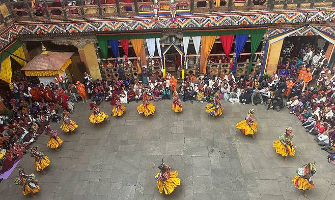 파로 종 안뜰에서 열린 파로 체추 축제. 황금색 치마 의상을 걸치고 가면을 쓴 승려들이 가면무를 공연하고 있다.