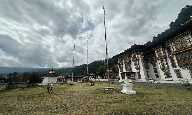 드넓은 잔디 광장에 높은 당간지주 세 개가 세워진 붐탕 자카르 종 안뜰. 7세기 송첸 감포가 세운 사원으로 부탄 불교의 역사적 심장부다.