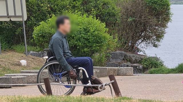 지난 22일 오후 대구 달성군 사문진나루터 산책로를 찾은 한 지체장애인이 수동휠체어를 탄 채 경사로를 힙겹게 올라온 뒤 강가를 바라보고 있다. 김용국 기자