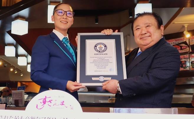지난 20일 일본의 스시 체인점 '스시 잔마이'를 운영하는 기요무라의 기무라 기요시 사장(74)이 도쿄 츠키지 수산시장에서 기네스북 인증서를 전달받고 있다./ 기요무라