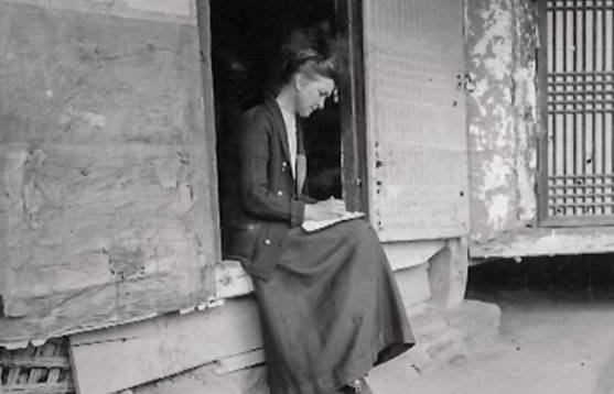 사애리시 선교사가 강경읍에 만동여학교를 지을 당시 초가교회의 문지방에 앉아 메모를 하고 있다. 1909년 경으로 추정된다. 사진=임연철 박사