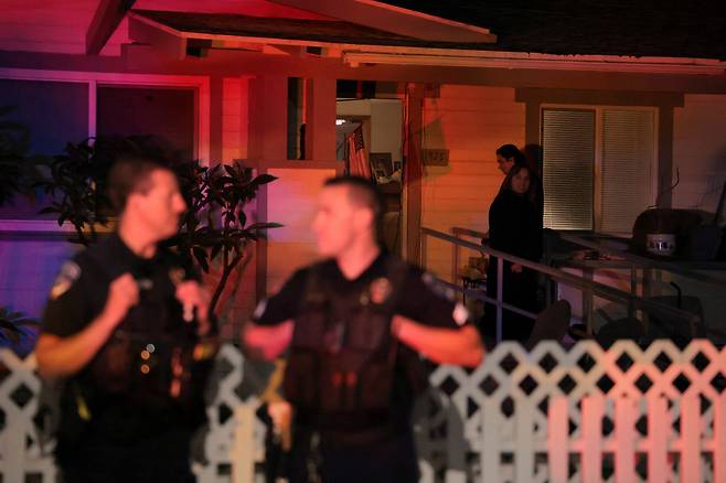 25일(현지시간) 미국 토런스에서 백악관 출입기자단 만찬 총격 사건 용의자 콜 토머스 앨런과 관련된 주택 인근에 경찰이 배치된 가운데, 주민들이 현장을 지켜보고 있다. 로이터연합뉴스