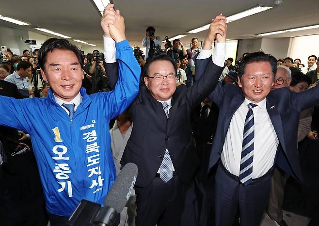 더불어민주당 김부겸 대구시장 후보(가운데)와 정청래 대표(오른쪽), 오중기 경북지사 후보가 26일 대구 달서구 두류역 인근에 마련된 김 후보의 희망캠프 선거사무소 개소식에서 손을 맞잡고 있다. 연합뉴스