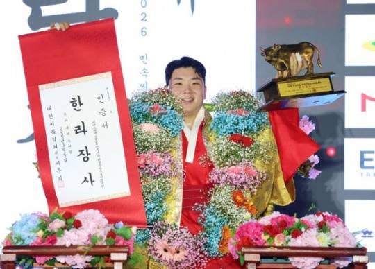 지난 3월 위더스제약 2026 민속씨름 단양온달장사씨름대회 한라장사(105㎏ 이하)에서 김무호(울주군청)가 장사꽃가마를 타고 장사인증서와 황소트로피를 들고 기념사진을 찍는 모습. [대한씨름협회 제공]