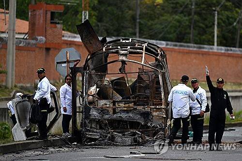 지난 24일(현지시간) 콜롬비아 서부 칼리 군기지 인근에서 발생한 폭발로 타버린 버스 [AFP=연합뉴스 제공]