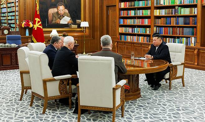 김정일 초상화 아래 마주앉은 북·러 김정은 북한 국무위원장(오른쪽)이 26일 평양에서 북한을 방문한 안드레이 벨로우소프(왼쪽 두 번째) 러시아 국방부 장관 등과 만나 회담을 가지고 있다. 김위원장과 벨로우소프 장관은 회담을 갖고 양국 간 군사 협력 강화 방안에 대해 논의했다. 평양=타스연합뉴스