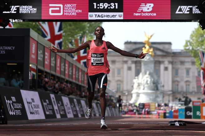 케냐 마라토너 사바스티안 사웨가 26일(한국시간) 영국 런던에서 열린 2026 런던마라톤에서 1시간 59분 30초 세계신기록으로 결승선을 통과하며 기뻐하고 있다. 런던 EPA 연햡뉴스