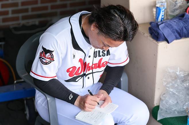 ▲ 울산 웨일즈 일본인 우완투수 고바야시 주이가 자신의 노트에 무언가를 적고 있다. ⓒ울산 웨일즈