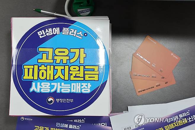 27일부터 고유가 피해지원금 지급 (서울=연합뉴스) 윤동진 기자 = 24일 서울 숭인2동주민센터에 마련된 고유가 피해지원금 신청 창구에 관련 부착물과 사용 카드가 놓여 있다.
    고유가 피해지원금은 이달 27일부터 5월 8일까지 기초생활수급자·차상위가구·한부모가족을 대상으로 우선 지급한다. 2026.4.24 mon@yna.co.kr