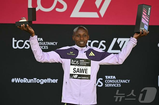세계 신기록을 기록한 케냐의 사바스티안 사웨가 26일 영국 런던에서 열린 2026 런던 마라톤 남자부 경기 시상식에서 트로피를 들고 있다. ⓒ AFP=뉴스1