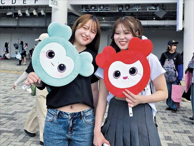 25일 일본 도쿄 국립경기장 무대에 한국 가수 최초로 선 트와이스 공연장을 찾은 팬들이 멤버들의 대형 초상화(위 사진)를 보며 즐거워하고 있다. 아래는 공연장 바깥에서 기념 사진을 찍는 팬들. /류정 기자