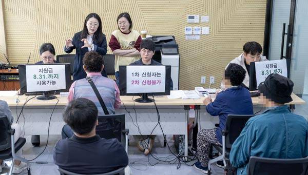 고유가 피해지원금 1차 지급일인 27일 부산 부산진구 가야1동주민센터에서 취약계층 대상자들이 선불카드를 신청하고 있다.  이원준 기자