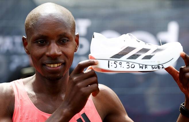 케냐의 사바스티안 사웨가 26일(현지시간) 영국 런던에서 열린 2026 런던 마라톤 남자 엘리트부 우승 뒤 1시간59분30초 기록 문구가 적힌 러닝화를 들어 보이고 있다. 로이터 연합뉴스