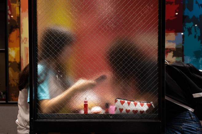 두 여학생이 패스트푸드점에서 마주 보고 각자 스마트폰을 하고 있다. 아동·청소년 대상 성착취 범죄의 심각성을 알리기 위한 전시회에서 연출된 모습. 실제로 가해자들은 청소년의 심리적·경제적 취약점을 노리고 스마트폰을 사용하는 모든 아이들을 노린다.  십대여성인권센터 제공