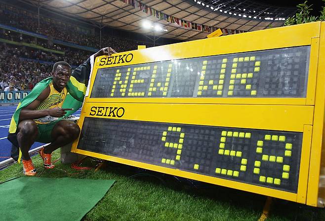 우사인 볼트가 2009 베를린 세계육상선수권대회 남자 100m에서 9초58로 세계신기록을 세운 뒤 기록 전광판 옆에서 포즈를 취하고 있다. Getty Images코리아