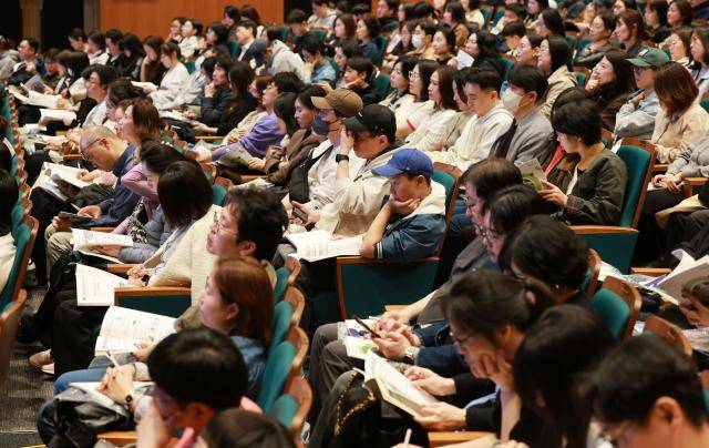 12일 서울 종로구 성균관대 600주년 기념관에서 열린 지역의사제 도입, 초중고 의대 및 대입변화 특집 설명회에서 참가자들이 자료를 살피고 있다.[사진=연합뉴스]