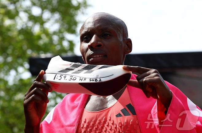 케냐의 세바스찬 사웨가 26일(현지시간) 1시간 59분 30초의 기록으로 세계 신기록을 경신하며 런던 마라톤 대회에서 우승한 뒤 아디다스 아디제로 아디오스 프로 에보 3 운동화를 들고 있다. 2026.4.26 ⓒ 로이터=뉴스1