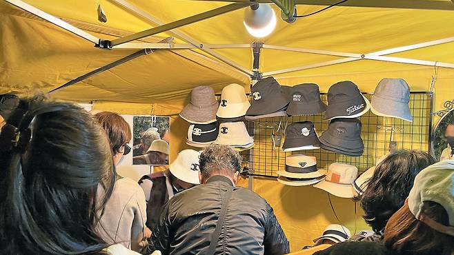 지난 23일 오후 9시 서울 동대문구 새빛시장의 한 짝퉁 모자 노점에 외국인 관광객 10여 명이 몰렸다. /김민혁 기자