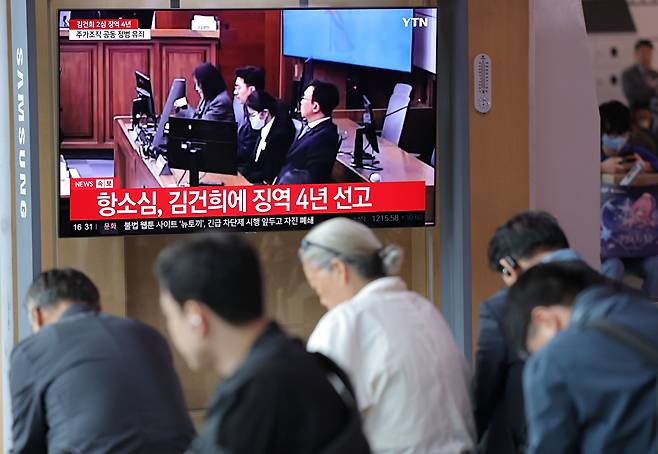 28일 서울역 대합실에서 시민들이 통일교 금품 수수와 도이치모터스 주가조작, 명태균 무상 여론조사 등의 혐의를 받는 김건희 여사 항소심 선고공판 생중계를 시청하고 있다. [사진=연합뉴스]