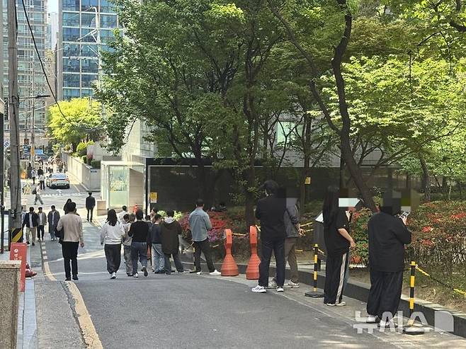 [서울=뉴시스] 김세은 인턴기자 =서울 강남구 테헤란로가 금연거리로 지정된 이후인 지난 24일 테헤란로 대로변을 피해 인근 골목에서 흡연하는 직장인들의 모습. 2026.04.24.