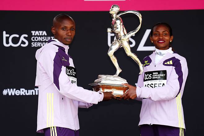 [런던=AP/뉴시스] 사바스티안 사웨(케냐)와 티지스트 아세파(에티오피아)가 26일(현지 시간) 영국 런던에서 열린 2026 런던 마라톤에서 각각 남녀부 차지한 후 시상대에 올라 포즈를 취하고 있다. 사웨는 1시간59분30초의 기록으로 마라톤 사상 처음으로 2시간 벽(서브 2)을 깨며 대회 2연패를 달성했고, 아세파는 2시간15분41초로 본인의 세계 기록을 9초 단축하며 우승했다. 2026.04.27.