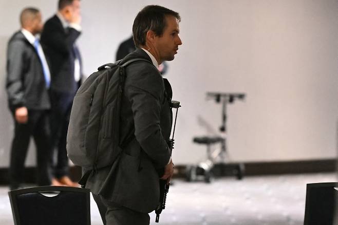 정장 차림의 요원이 25일(현지시간) 미국 워싱턴DC 워싱턴 힐튼호텔에서 열린 백악관 출입기자단 만찬 총격 시도 이후 장총을 든 채 이동하고 있다. AFP 연합뉴스