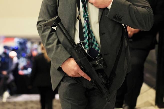 정장 차림의 요원이 25일(현지시간) 미국 워싱턴DC 워싱턴 힐튼호텔에서 열린 백악관 출입기자단 만찬 총격 시도 이후 소형 자동화기를 든 채 계단 주변을 경계하고 있다. AFP 연합뉴스