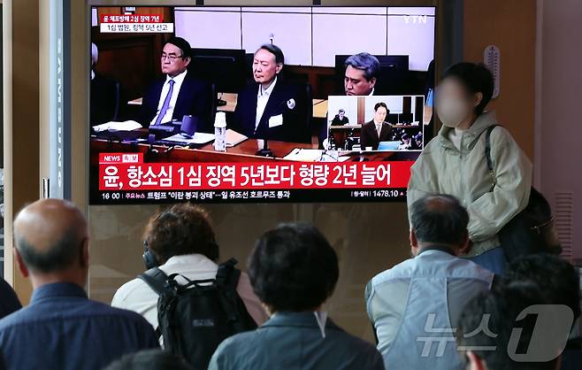 29일 오후 서울시 용산구 한강대로 서울역 대합실에서 시민들이 특수공무집행방해, 직권남용 권리행사방해, 허위 공문서 작성 등의 혐의를 받는 윤석열 전 대통령의 항소심 선고 공판 생중계를 지켜보고 있다. 윤 전 대통령은 지난 1심 징역 5년 보다 2년 높은 징역 7년형을 선고 받았다. 2026.4.29 ⓒ 뉴스1 김진환 기자