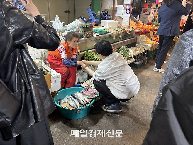 한동훈 전 국민의힘 대표가 부산 북구 구포시장에서 상인과 만나 이야기를 하고 있다. <신지윤 기자>