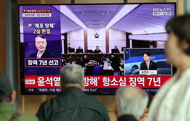 고위공직자범죄수사처 체포방해 등 혐의로 기소된 윤석열 전 대통령의 항소심 선고 공판 생중계 방송이 29일 서울역 대합실에서 TV를 통해 송출되고 있다. 연합뉴스