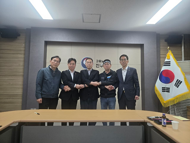 화물연대와 BGF로지스 교섭 대표자들이 29일 노동부 진주지청에서 열린 5차 교섭에서 잠정 합의안을 도출하고 김영훈(왼쪽 두번째) 고용노동부 장관, 김주영(오른쪽 첫번째) 더불어민주당 의원과 서로 손을 잡고 있다.  사진제공=화물연대
