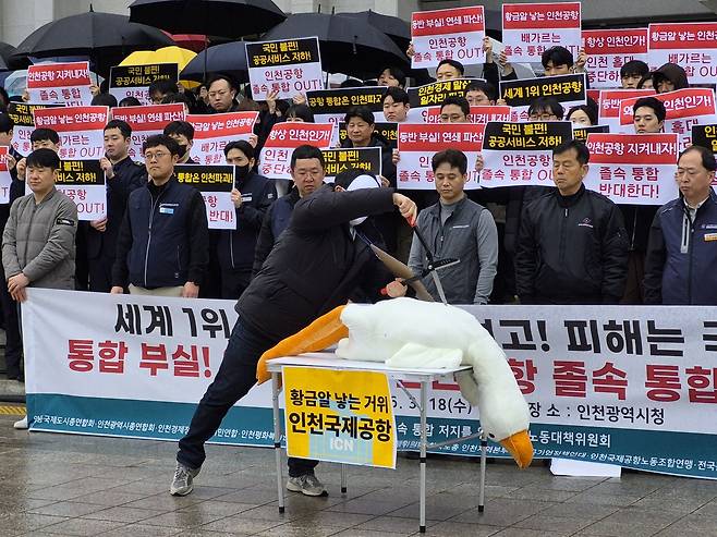 지난 4월 인천시청에서 인천지역 시민사회노동단체들이 인천공항 통합에 반대하며 황금알을 낳은 거위의 배를 가르는 퍼포먼스를 하고 있다. 인천시민단체 제공