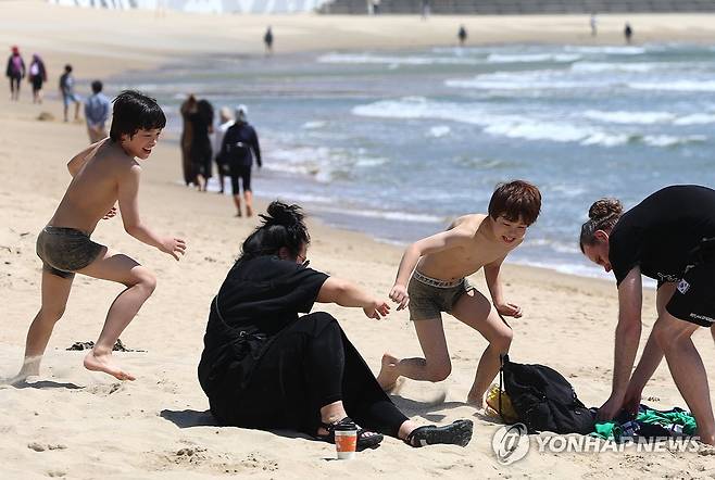 부산 해운대해수욕장에서 물놀이 즐기는 외국인 관광객 가족 [연합뉴스 자료사진]