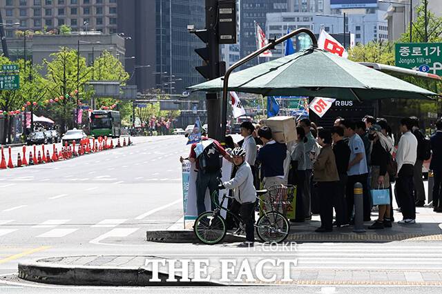 예년보다 빠르게 찾아온 더위에 온열질환 우려가 커지자 서울 자치구들은 그늘막 운영을 앞당기며 폭염 대응에 나섰다. 사진은 서울 낮 최고기온이 28도를 기록하며 초여름 날씨를 보인 지난 16일 오후 서울 종로구 세종대로 사거리에서 시민들이 그늘막에 들어가 햇빛을 피하고 있는 모습. /김성렬 기자