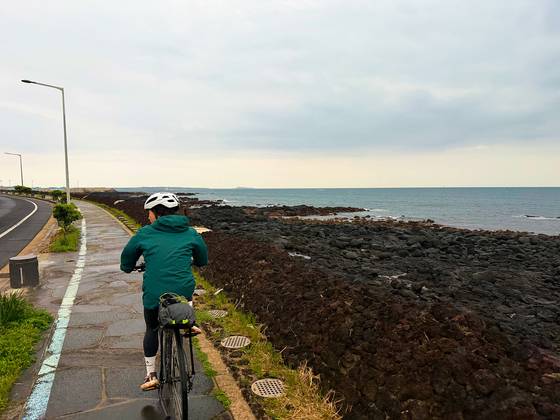 Riding in the rain-swept southwest of Jeju on April 3. Jeju Island sits very exposed in the middle of the Korea Strait, and cyclists should be prepared for all possible weather. [JIM BULLEY]