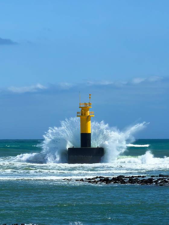 Waves break over a light house in Seogwipo on April 4. [JIM BULLEY]