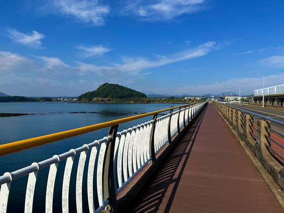 Riding across the water to the Seongsan Ilchulbong stamp booth on April 5. [JIM BULLEY]