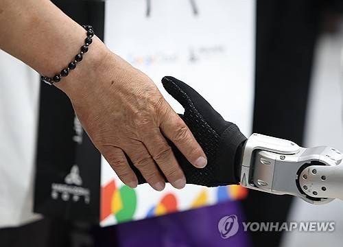 금속과 영혼의 만남  (서울=연합뉴스) 김도훈 기자 = 11일 서울 강남구 코엑스에서 열린 제14회 스마트테크코리아에 참가한 한 업체 부스에서 휴머노이드 로봇과 관람객이 악수를 하고 있다. 2025.6.11 superdoo82@yna.co.kr