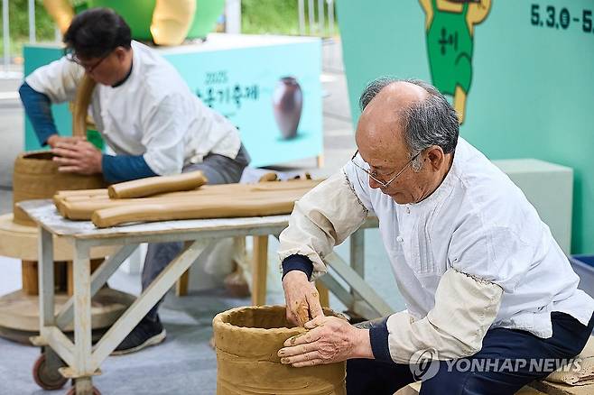 옹기 빚는 장인들 (울산=연합뉴스) 지난해 5월 울산 울주군 온양읍 외고산 옹기마을 일대에서 울산 대표 문화관광축제인 '2025 울산옹기축제'가 열린 가운데 옹기장인들이 옹기를 빚는 모습. 2025.5.4 [울주문화재단 제공.재판매 및 DB 금지] young@yna.co.kr