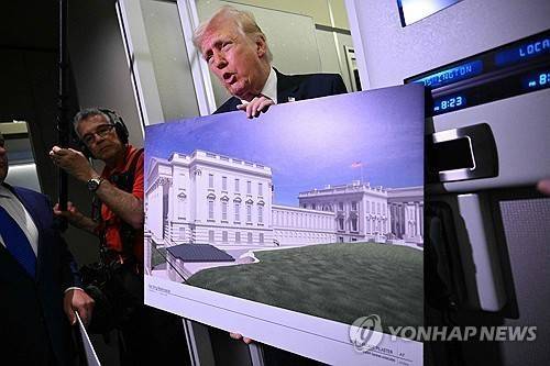 지난 3월 29일 미국 메릴랜드주 앤드루스 합동기지로 향하는 미국 대통령 전용기 에어포스원 기내에서 도널드 트럼프 미국 대통령이 백악관 연회장 설계안을 담은 대형 포스터를 기자들에게 보여주고 있다. [연합뉴스]