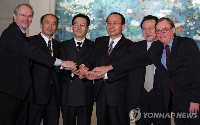 2005년 6월 정동영 통일부 장관의 김정일 북한 국방위원장 독대는 6자회담 재개로 이어져 북한 비핵화를 명시한 9·19 공동 성명 에 기여했다. 북핵 6자회담의 대표들이 9·19 성명 발표 후, 손을 모아 웃고 있다. 왼쪽에서 네 번째가 송민순 한국 측 대표, 그 오른쪽이 김계관 북한 측 대표./연합뉴스