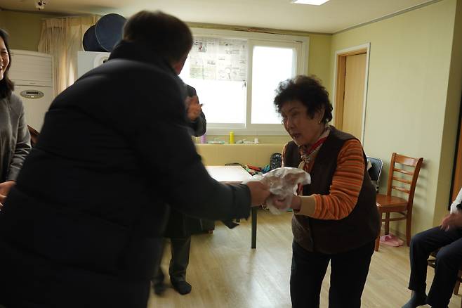김재곤 회장이 지난 2023년 12월 지역 내 경로당을 찾아 닭을 선물하고 있다. [가마치 제공]