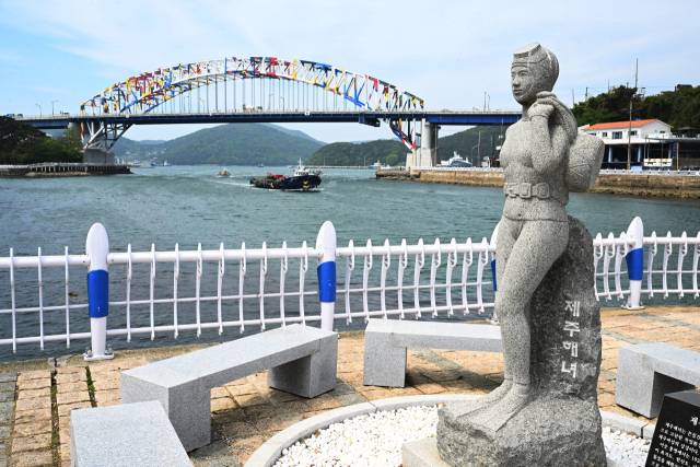 통영운하에서통영해양관광공원 방향으로 걷다 보면 제주해녀상 너머로 통영대교가 보인다. 통영대교에는 전혁림 화백의 작품 풍어제 가 형상화돼 있다.